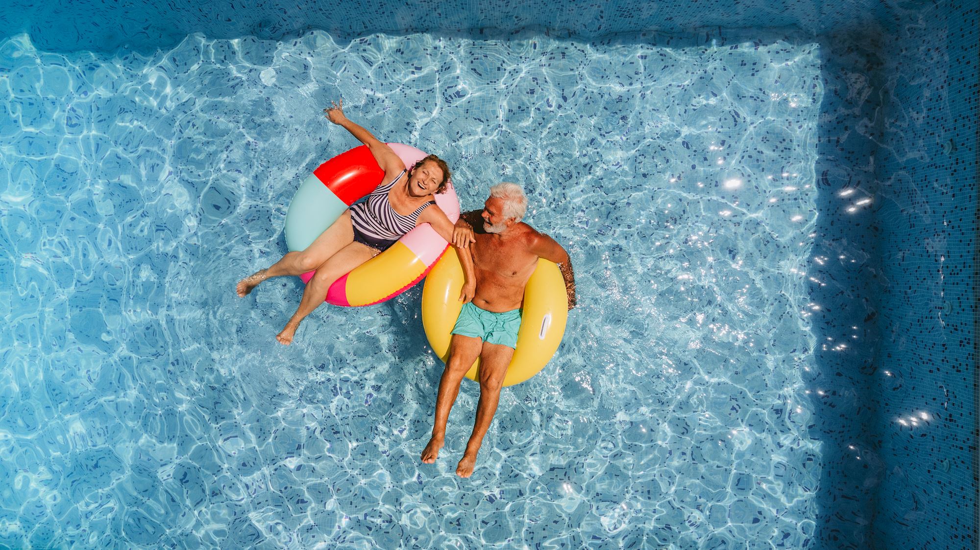 Mature aged couple lying in a pool